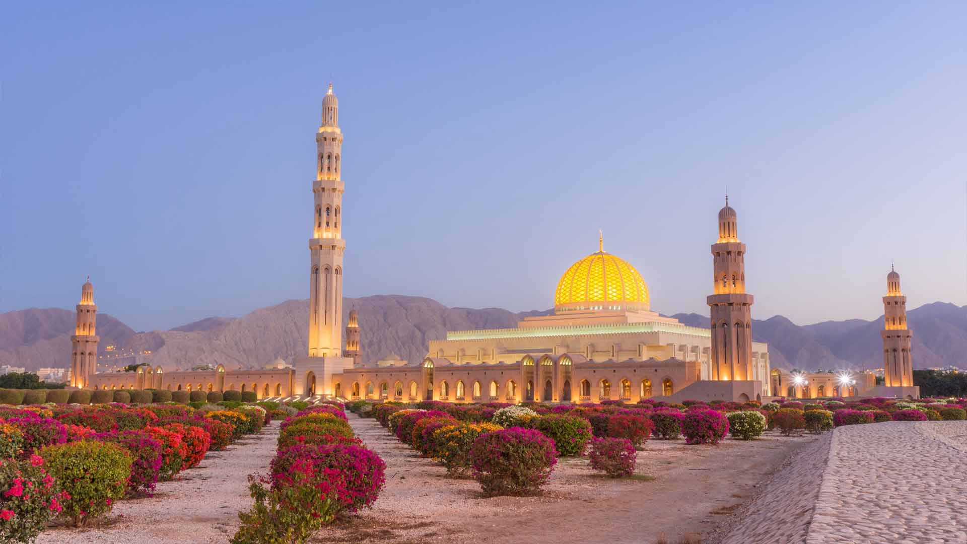 The stunning Sultan Qaboos Grand Mosque in Muscat at sunset, a highlight among the Top Oman Tourist Attractions 2024.